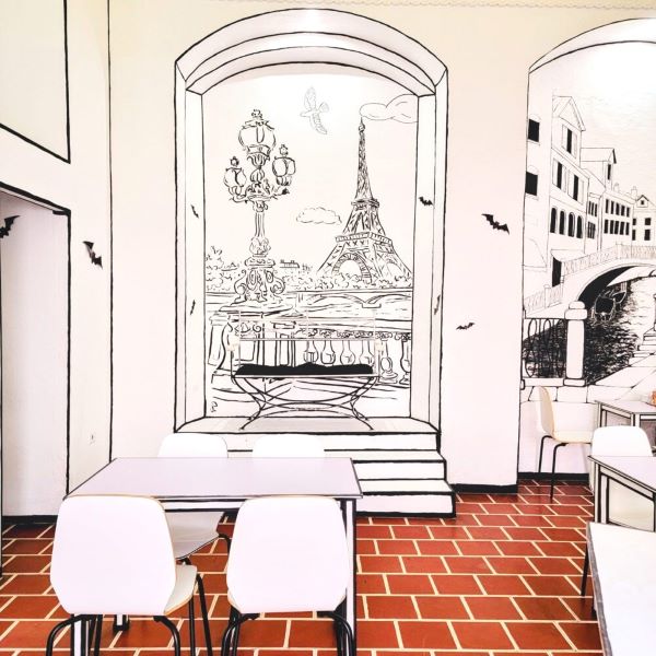 Cafe Bocetos seating area with wall sketches